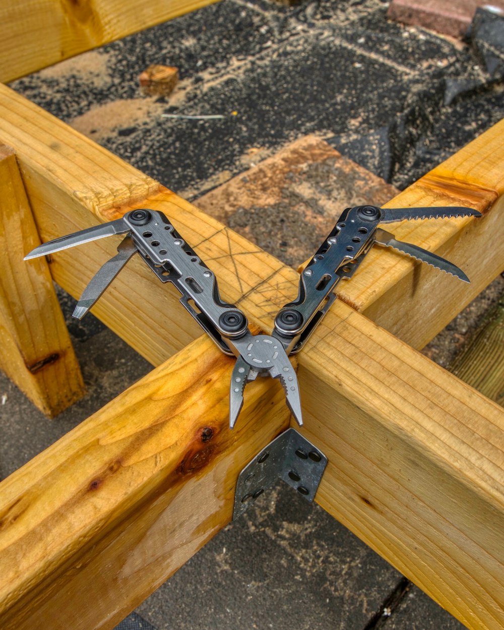 gray metal tool on brown wooden plank