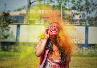 woman in pink tank top with yellow powder on her face