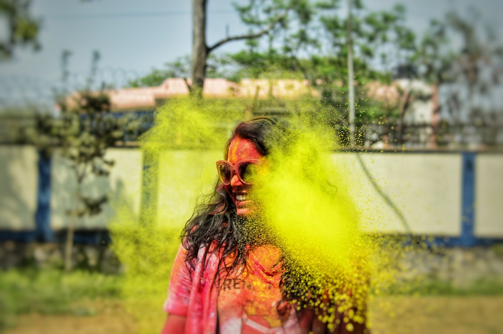 Mujer en chaqueta rosa con humo amarillo en la cara