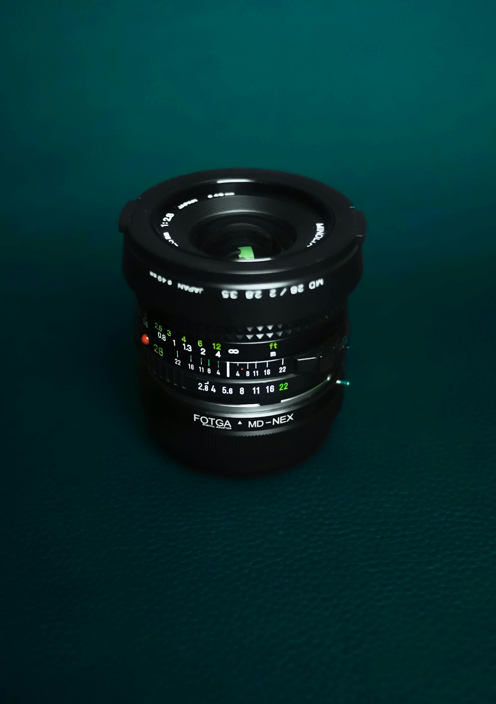 Schwarzes Kameraobjektiv auf grüner Oberfläche