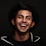 A happy young man wearing a stylish jacket from Brito Zone, smiling confidently.