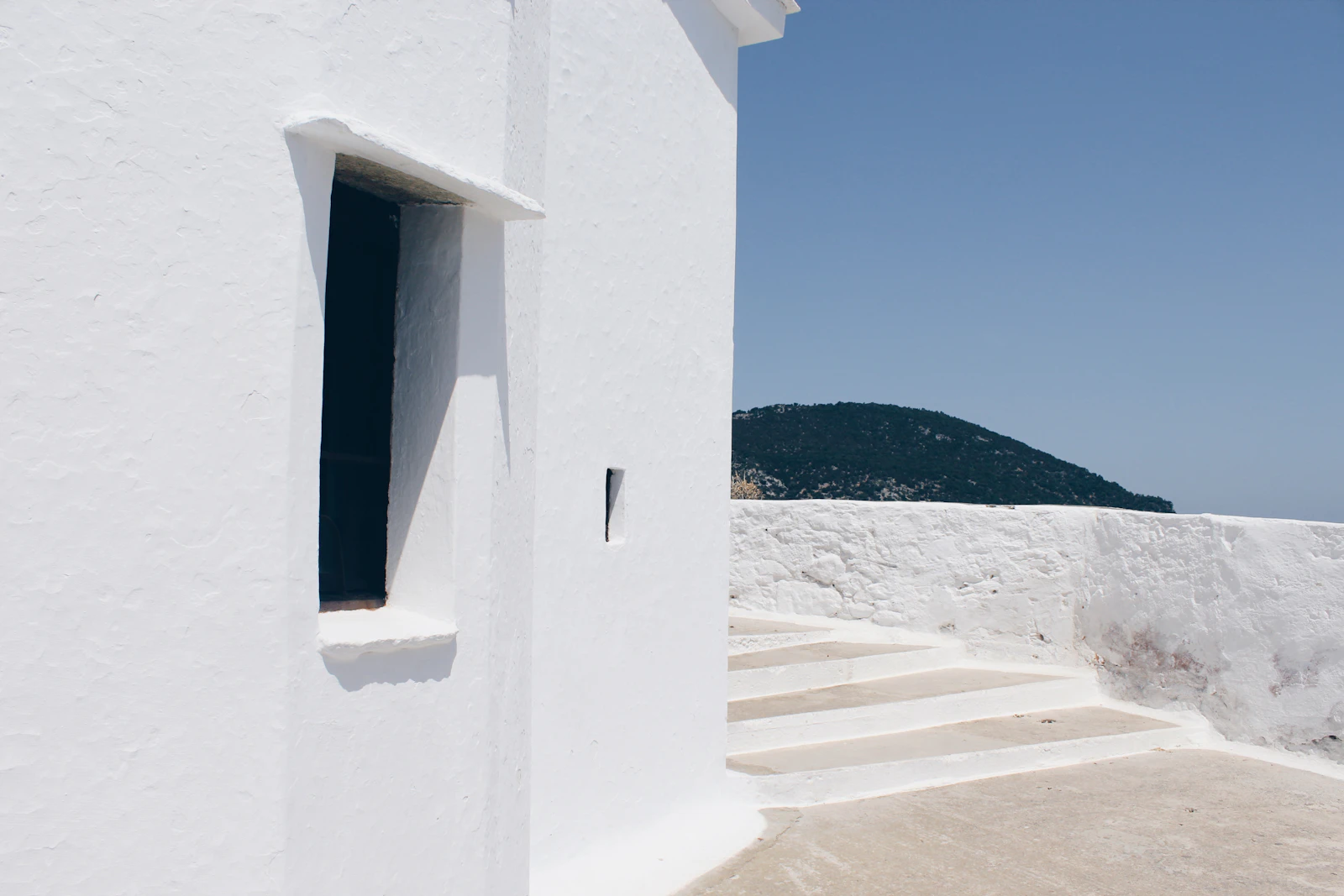 A whitewashed chapel wall and steps against the sea, Skopelos