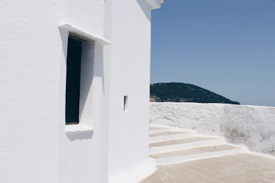 A whitewashed chapel wall and steps against the sea, Skopelos