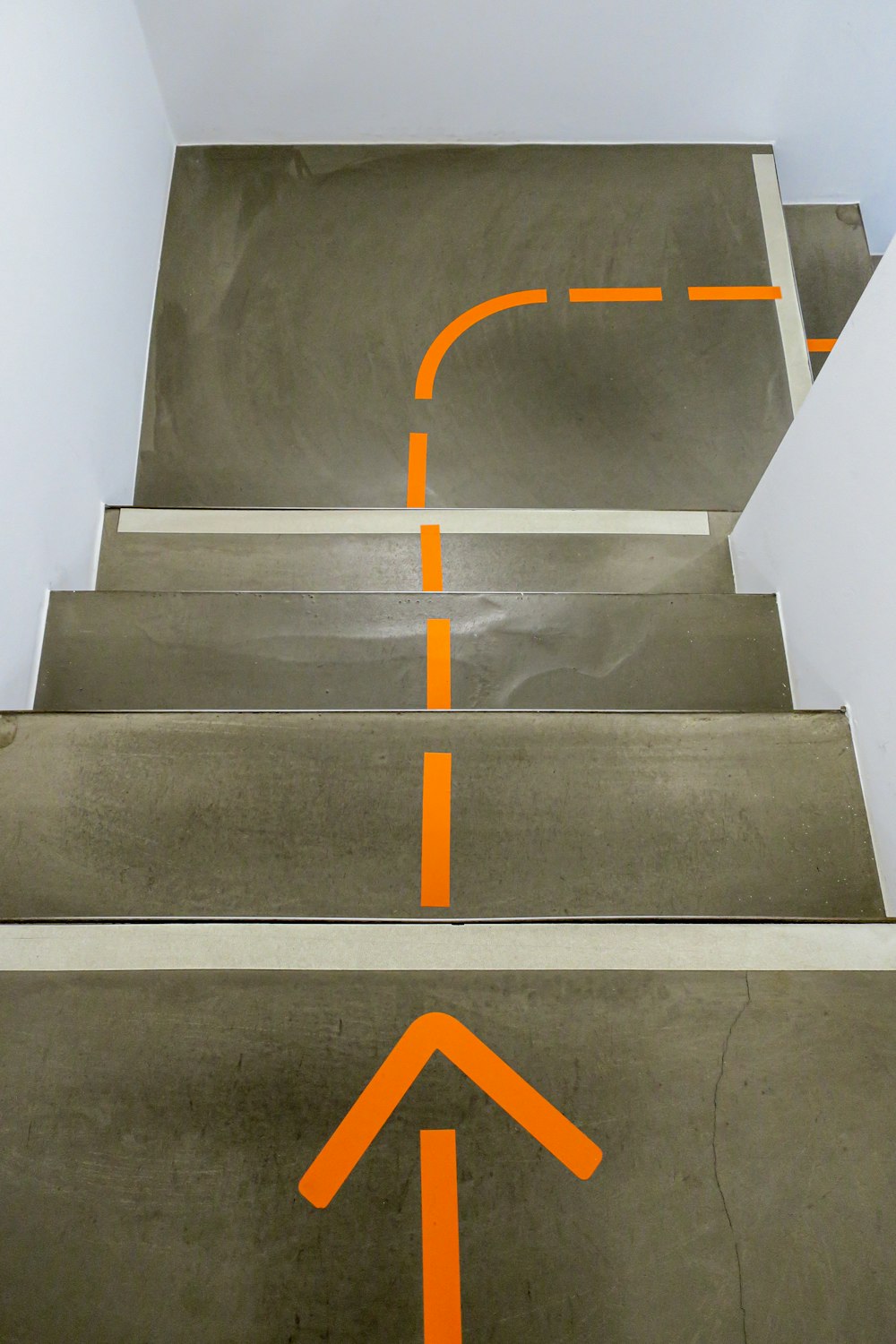 Escaleras de hormigón gris con señal de flecha amarilla