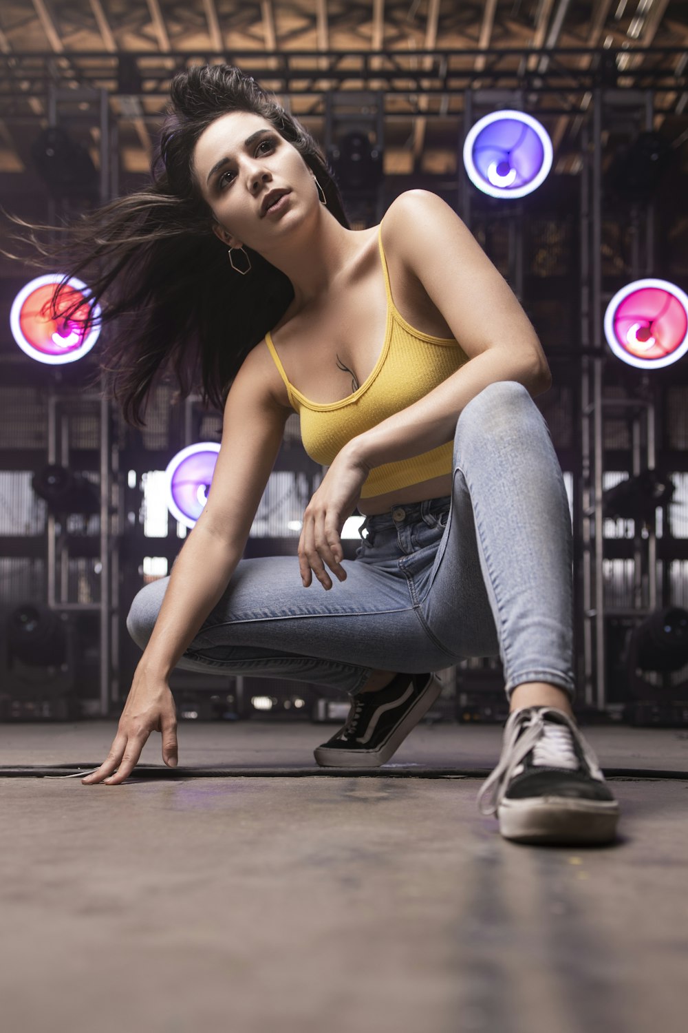 woman in yellow sports bra and blue denim jeans sitting on floor