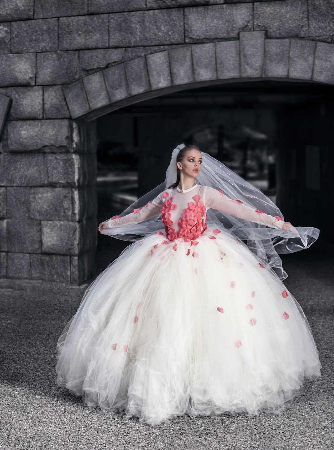 woman in white and red floral wedding dress standing on gray concrete stairs