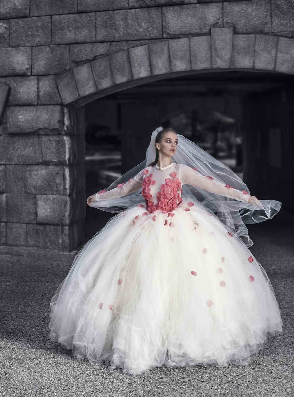 woman in white and red floral wedding dress standing on gray concrete stairs