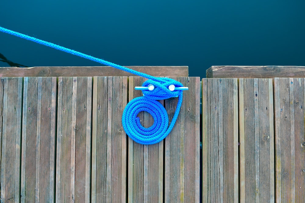 blue strap on brown wooden fence