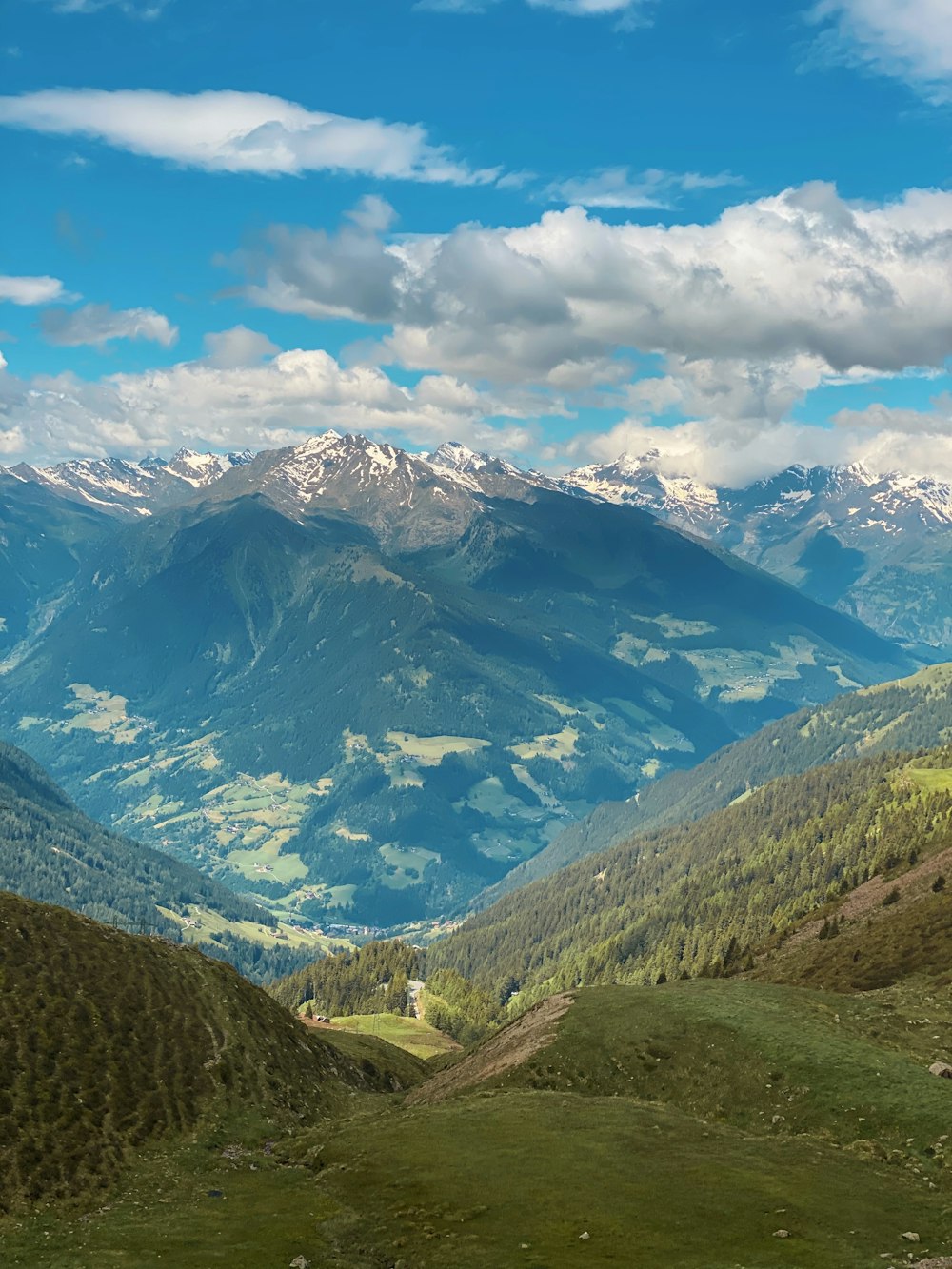 green and white mountains under white clouds and blue sky during daytime