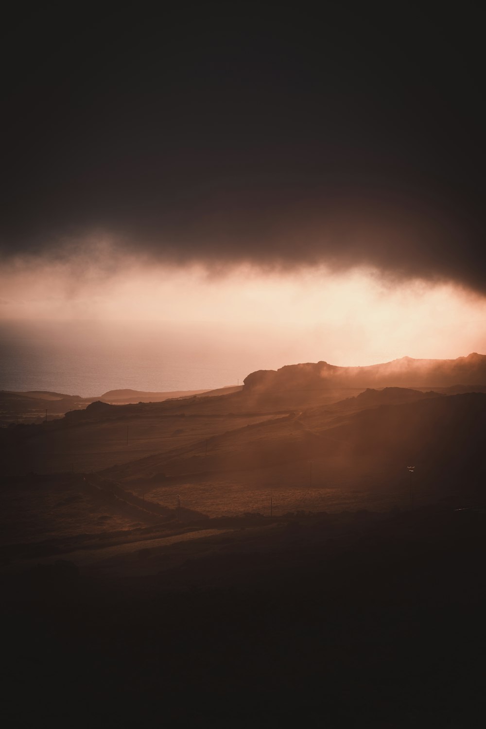 silhouette of mountains under cloudy sky during daytime