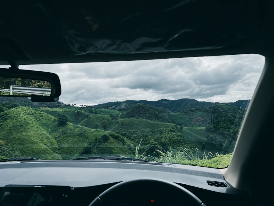 View through a windshield of rolling green hills from inside a moving vehicle