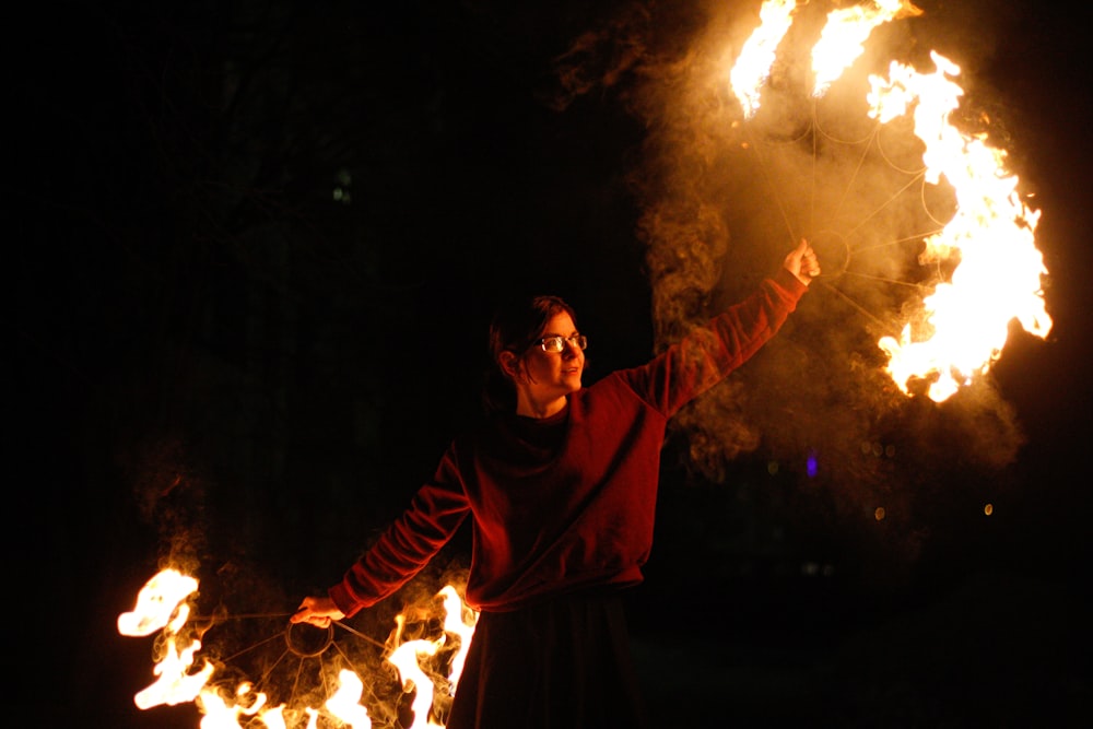 man in black robe holding fire