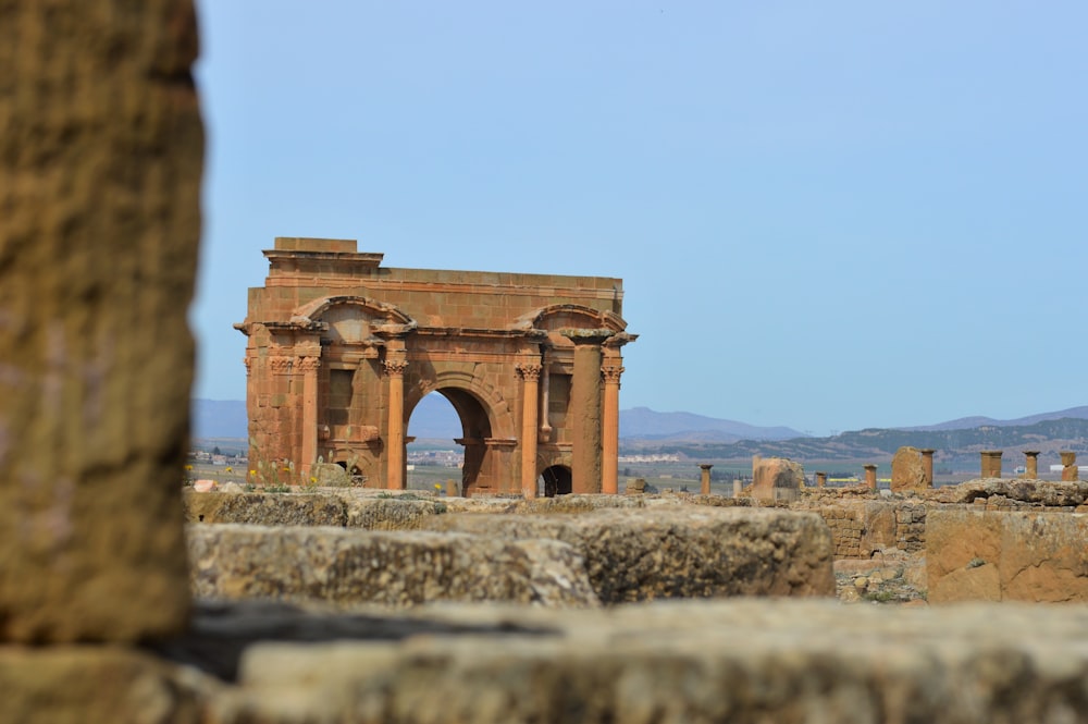 Arco de hormigón marrón bajo el cielo azul durante el día