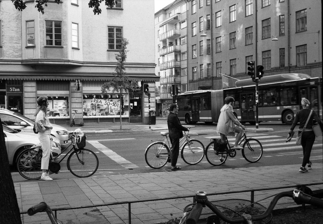grayscale photo of people riding bicycle on street