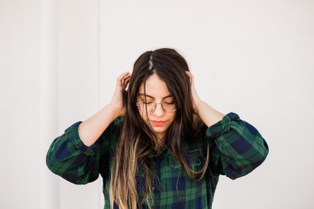 woman in green and black plaid dress shirt smiling