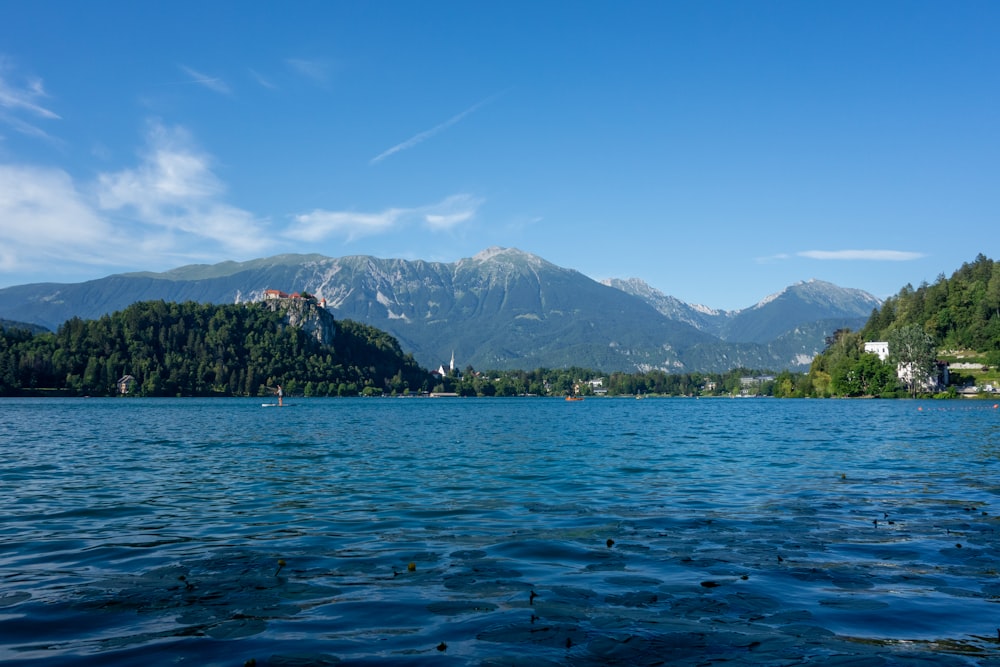 green and brown mountains beside body of water under blue sky during daytime