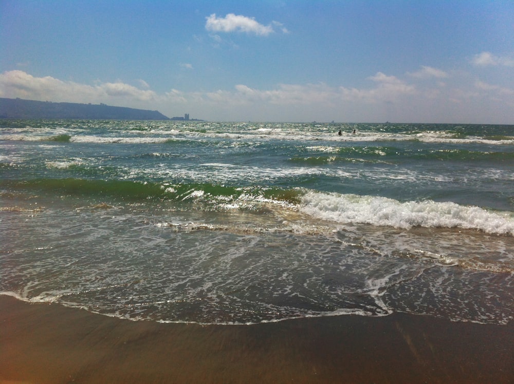 ocean waves crashing on shore during daytime