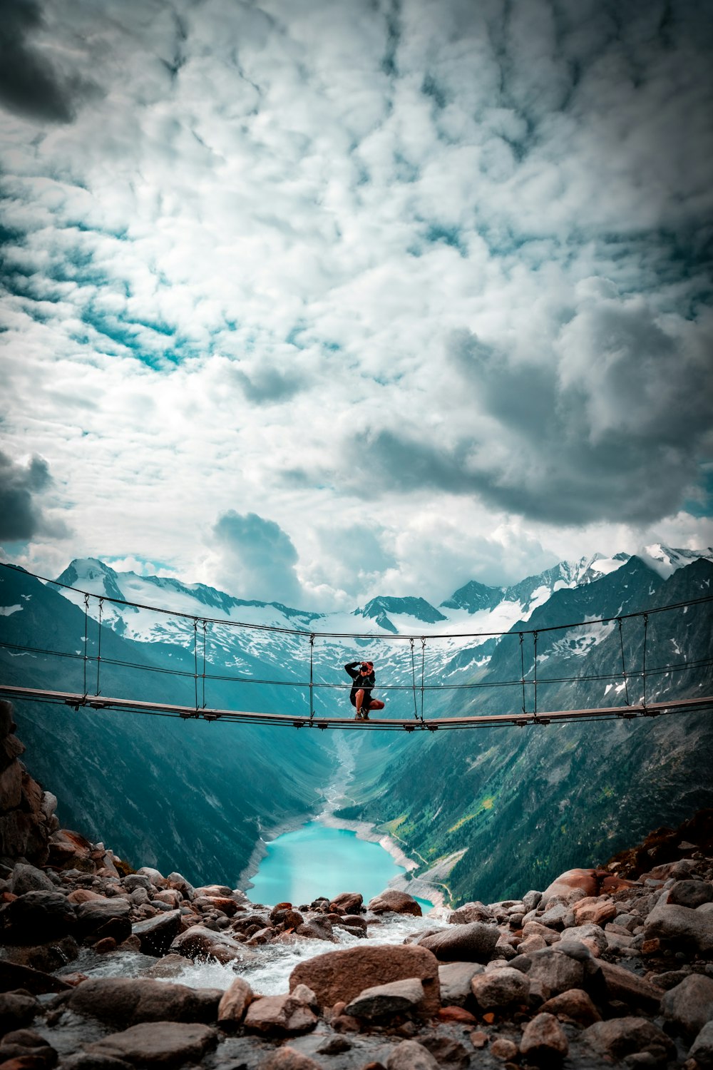 2 person standing on rock formation under white clouds during daytime