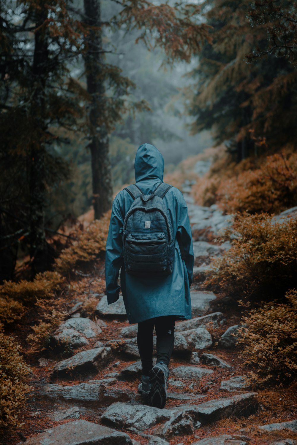 person in gray hoodie standing on brown dirt road during daytime