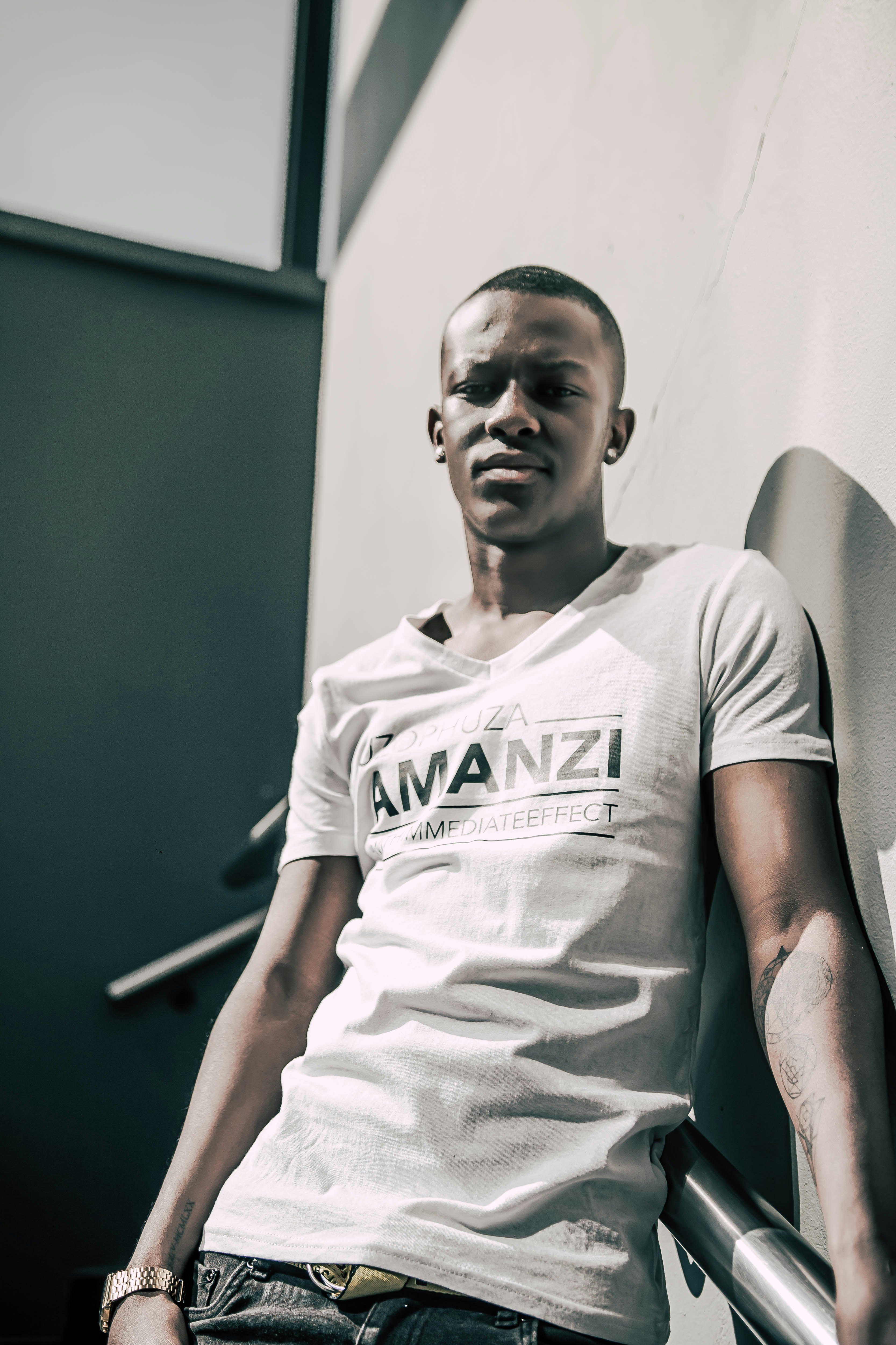 man in white crew neck t-shirt sitting on gray chair