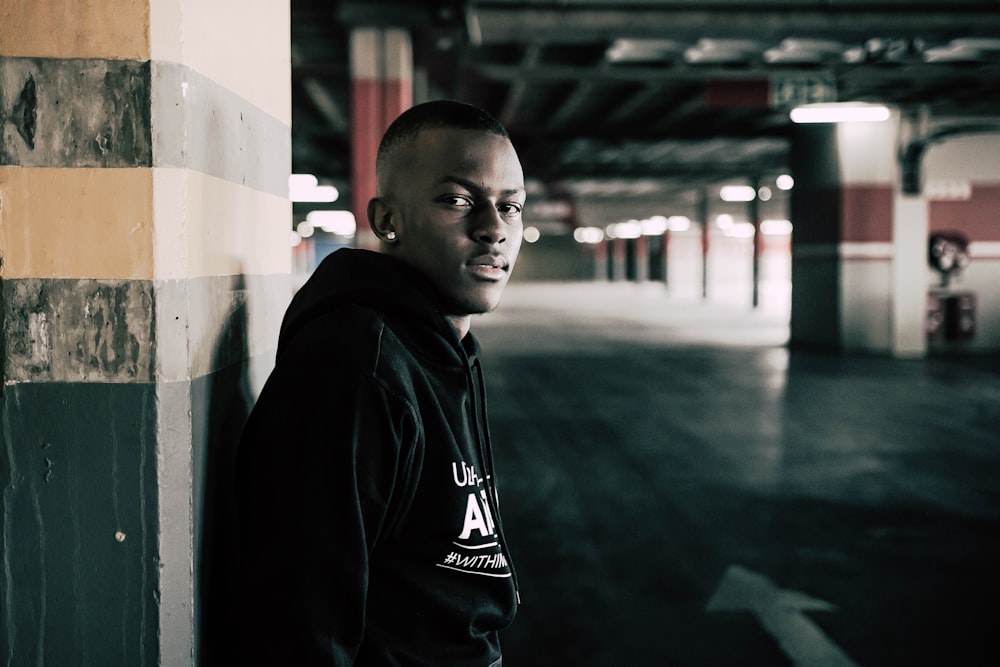 man in black hoodie standing on wet floor