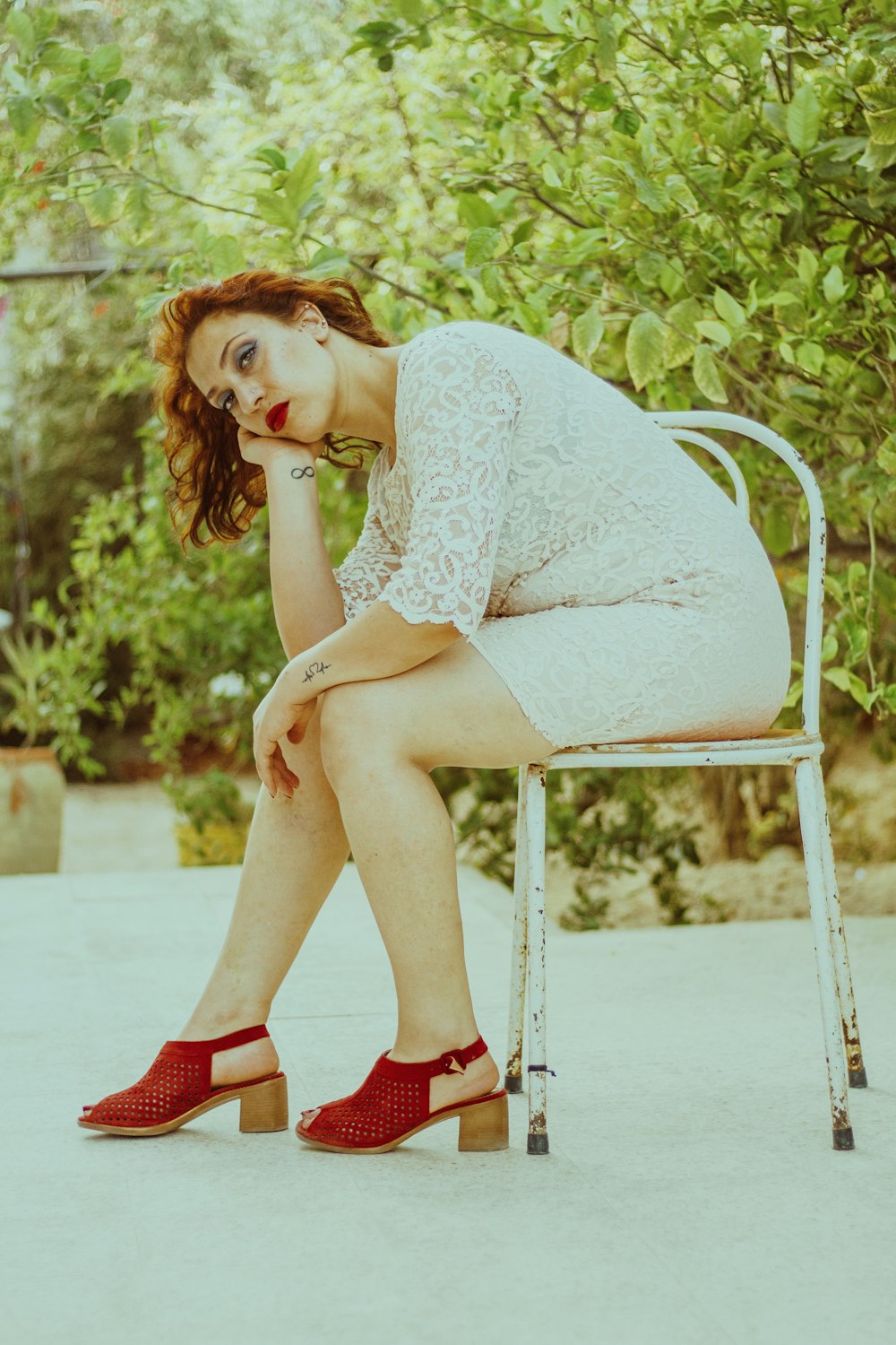 woman in white lace dress sitting on white chair