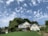 A beautiful single-family home with a well-manicured lawn and a clear blue sky.