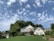 A beautiful single-family home with a well-manicured lawn and a clear blue sky.