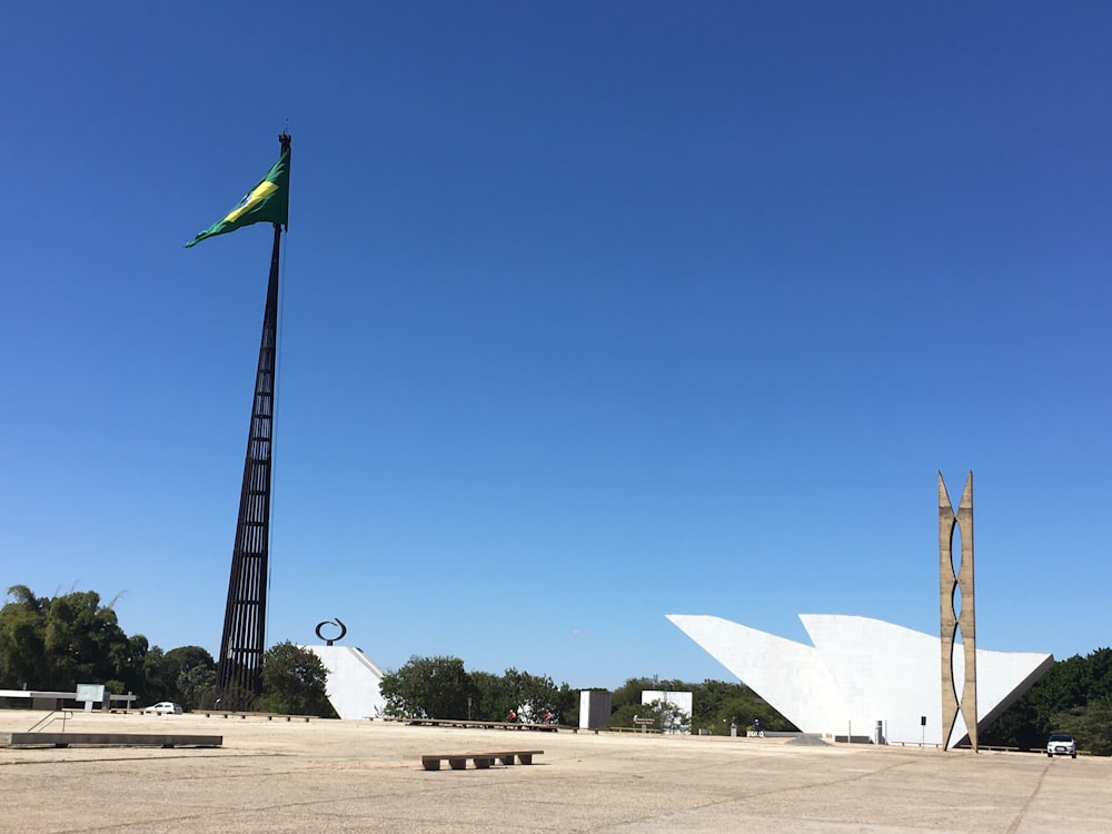 drapeau blanc et vert sur un champ brun sous un ciel bleu pendant la journée