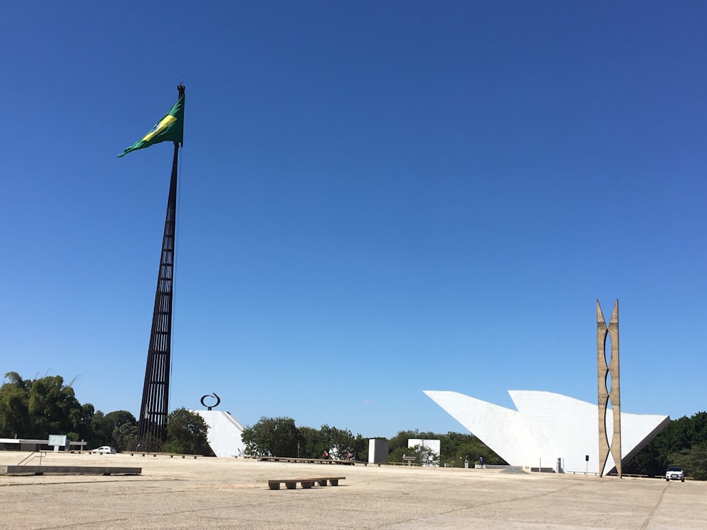 white and green flag on brown field under blue sky during daytime