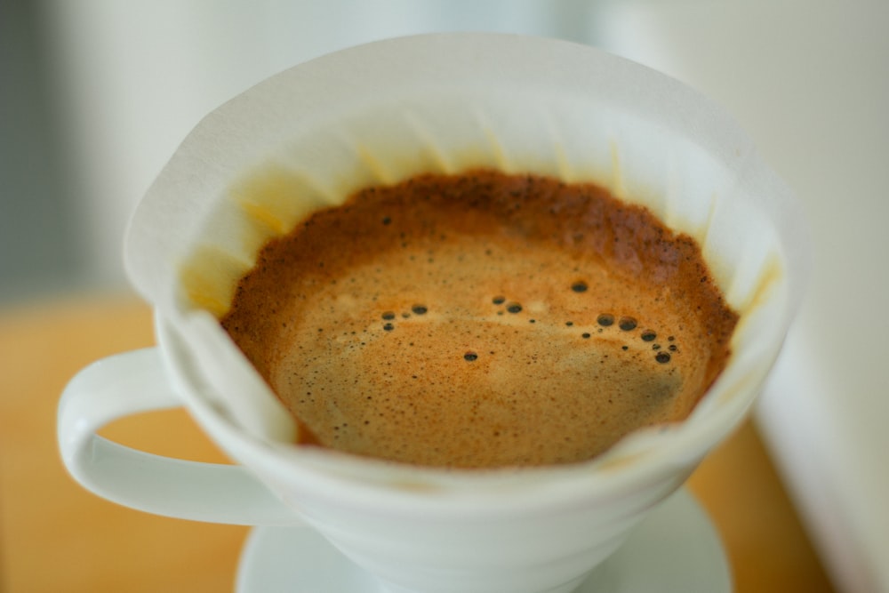 white ceramic mug with brown liquid