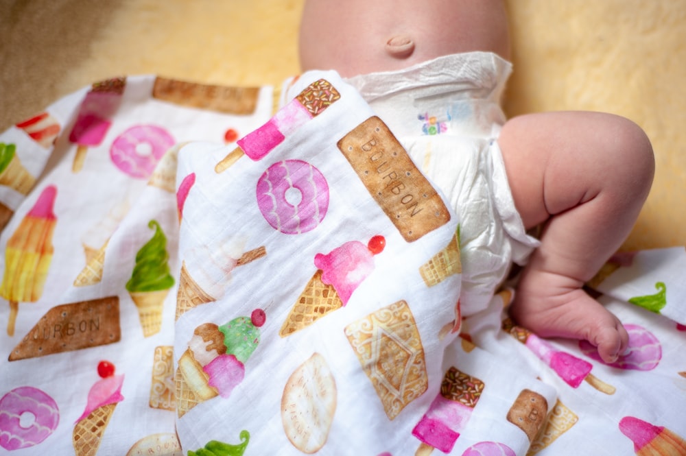 Baby in weißem und rosa Blumenonesie