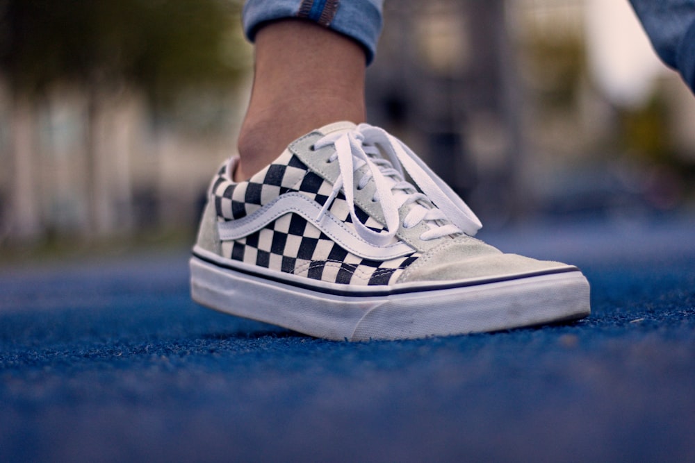 person wearing white and blue nike sneakers