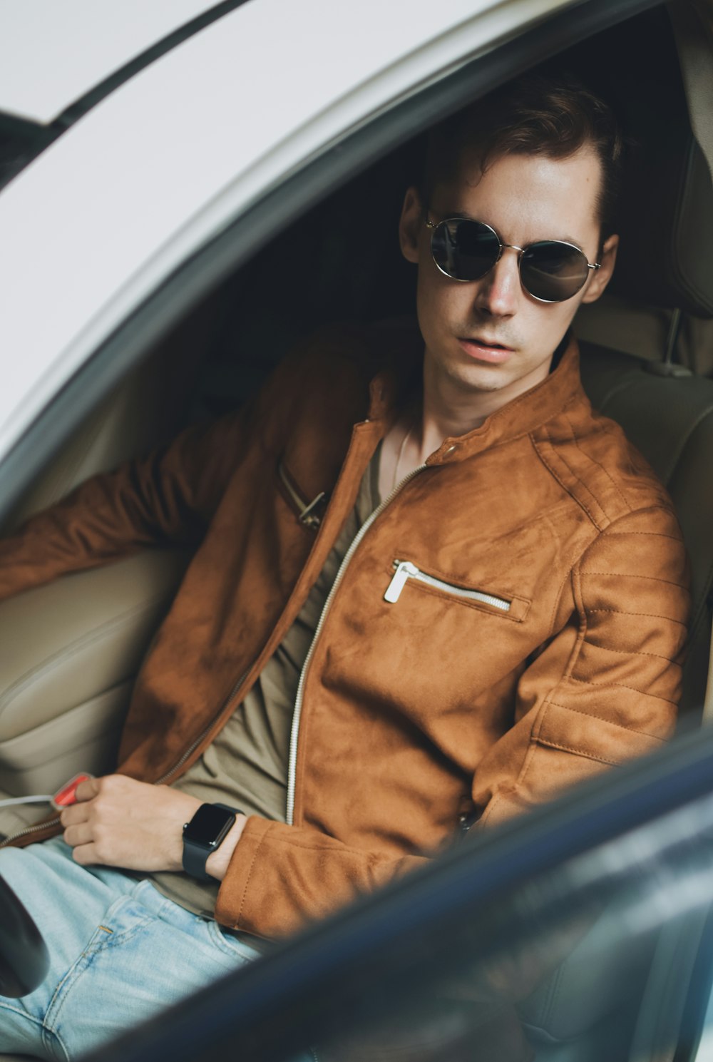 man in brown leather jacket wearing black sunglasses