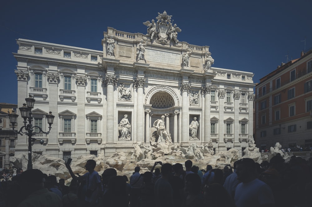 people standing in front of white concrete building during daytime