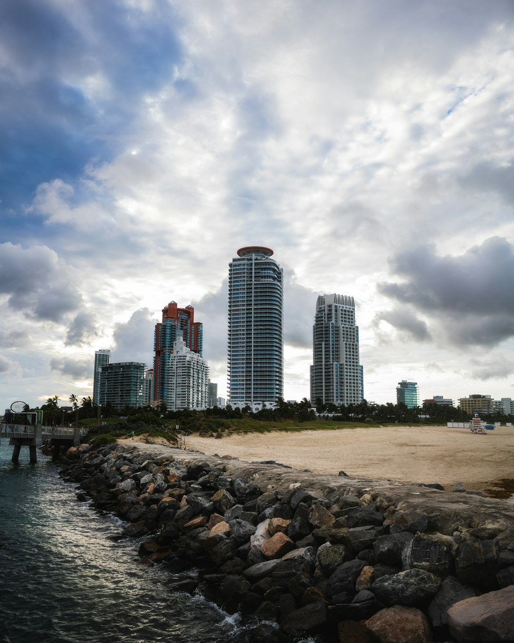 body of water near city buildings under cloudy sky during daytime