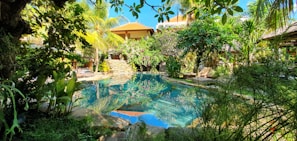 A serene swimming pool surrounded by tropical gardens in a villa