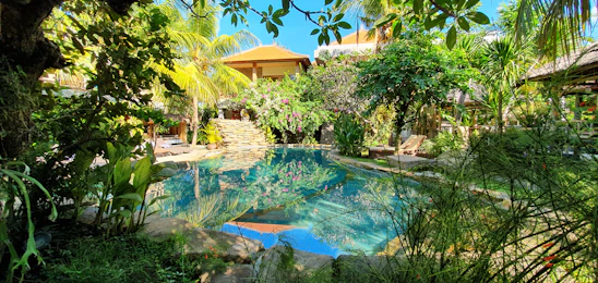 A serene private pool villa in Da Nang surrounded by lush greenery and a clear blue sky.