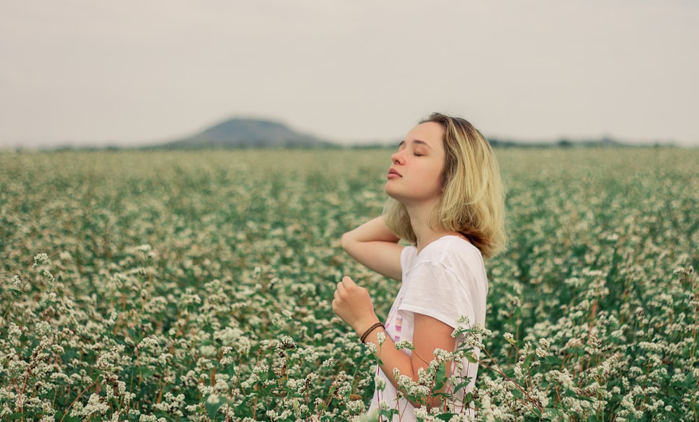 girl in white shirt on flower field during daytime