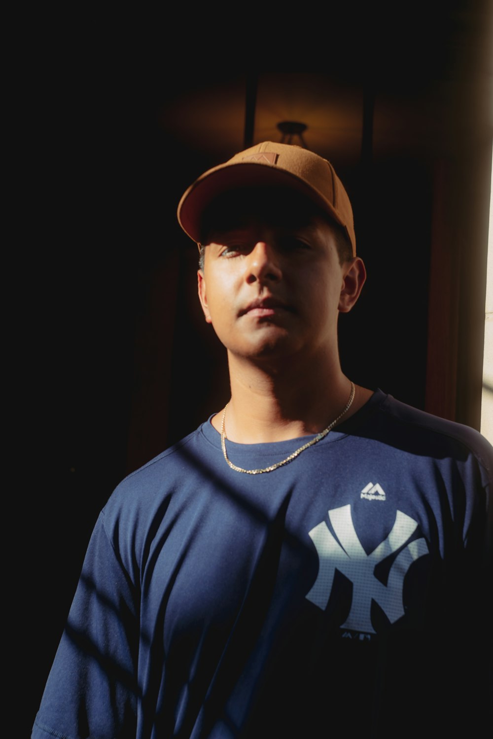 a young man wearing a baseball cap and a blue shirt