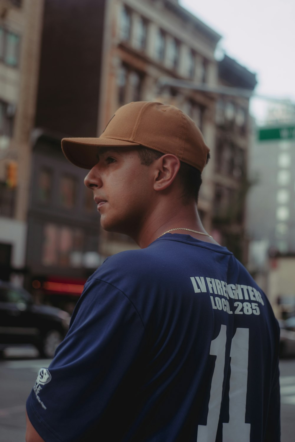 a man wearing a hat standing on a street corner