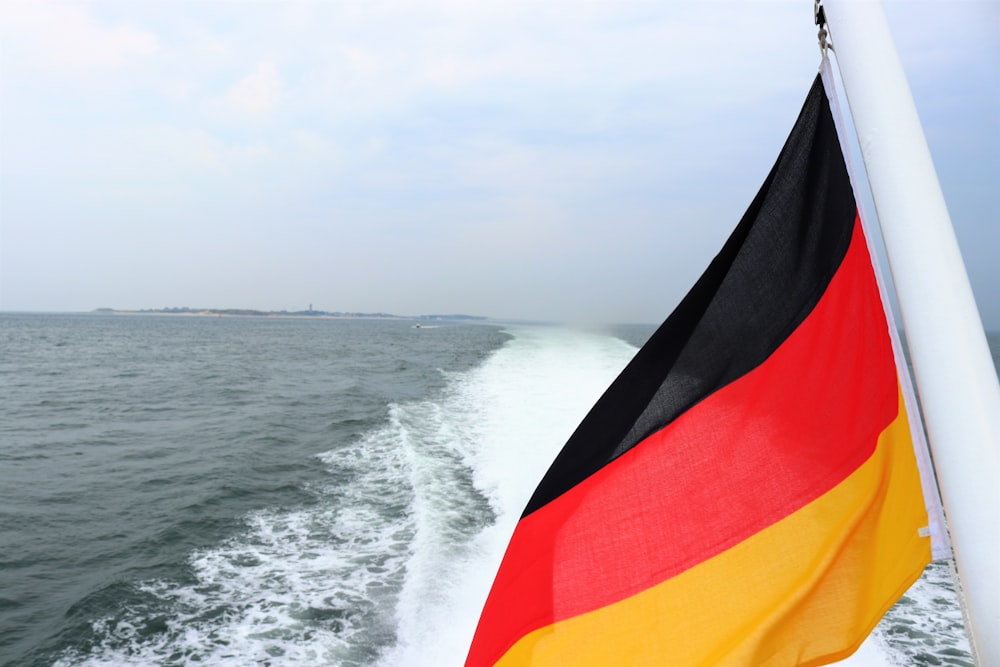 red yellow and black flag on beach during daytime