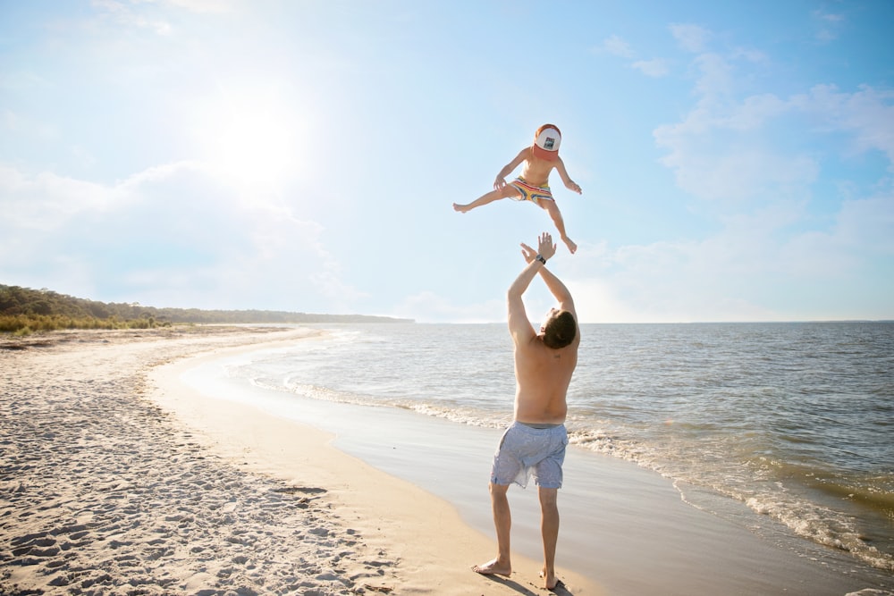 man in white shorts standing on beach during daytime