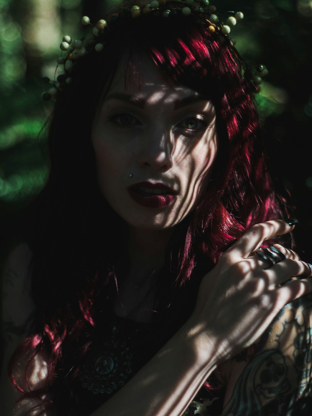 woman with red hair covering her face with her hand