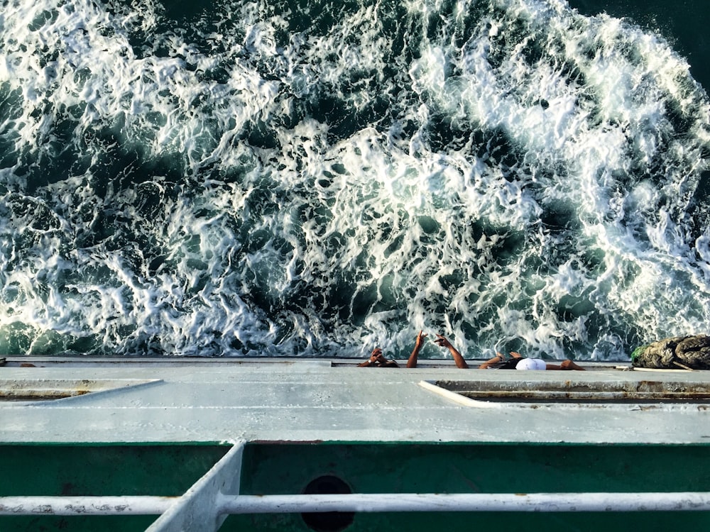 Person im roten Hemd, die tagsüber auf einem weißen Boot auf einem Gewässer fährt