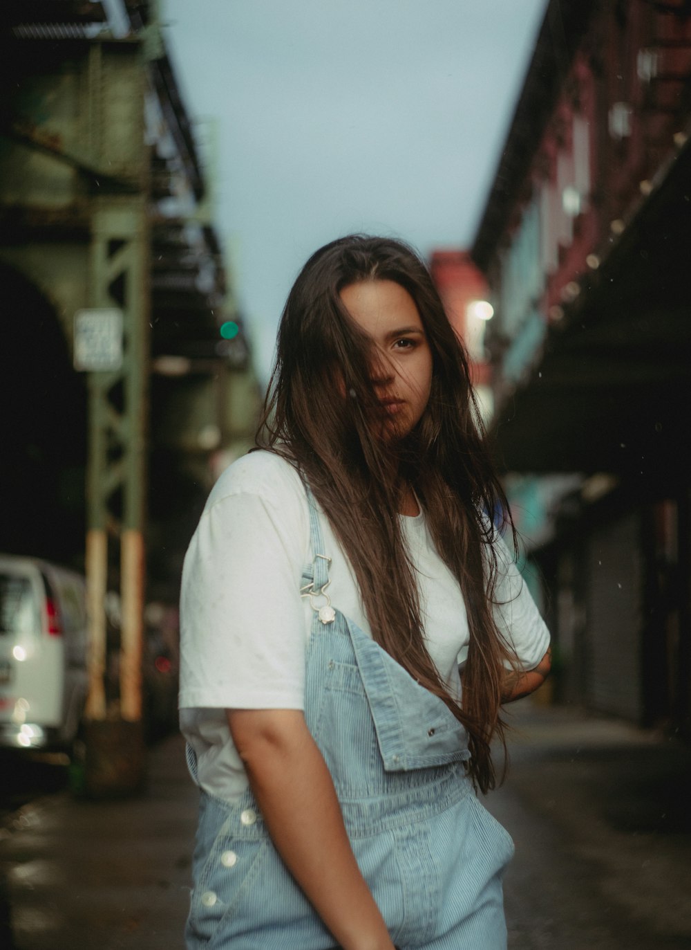 a woman with long hair standing on a street