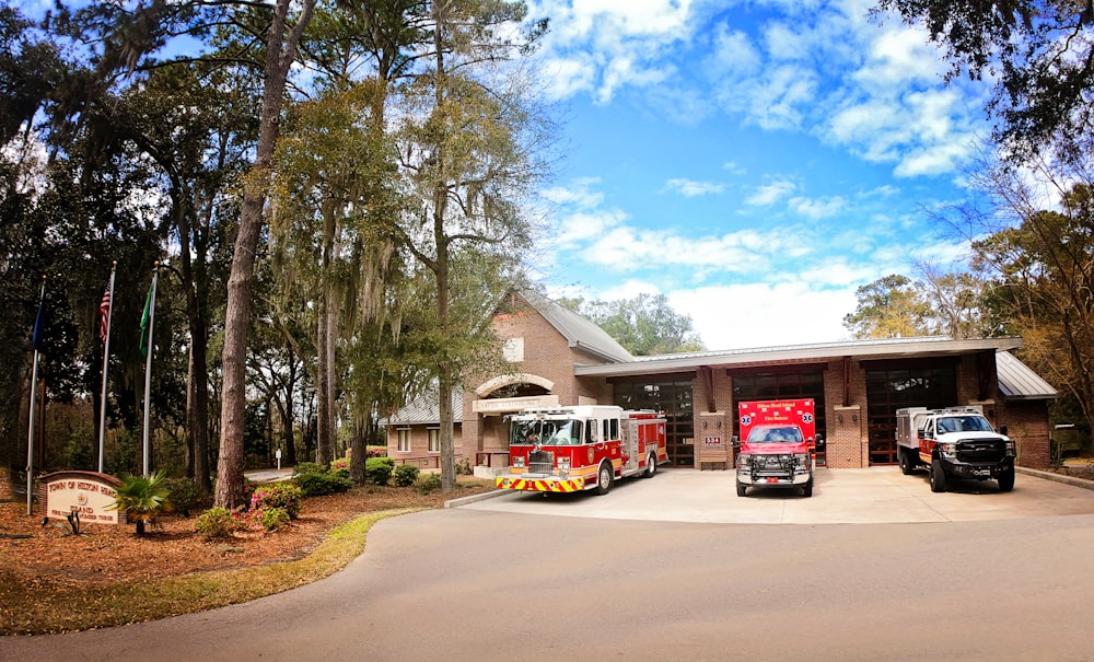 three fire trucks parked in front of a fire station