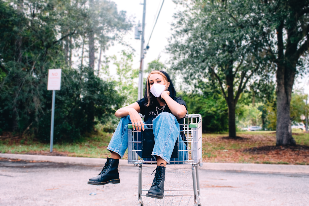 woman in blue denim vest sitting on gray metal chair