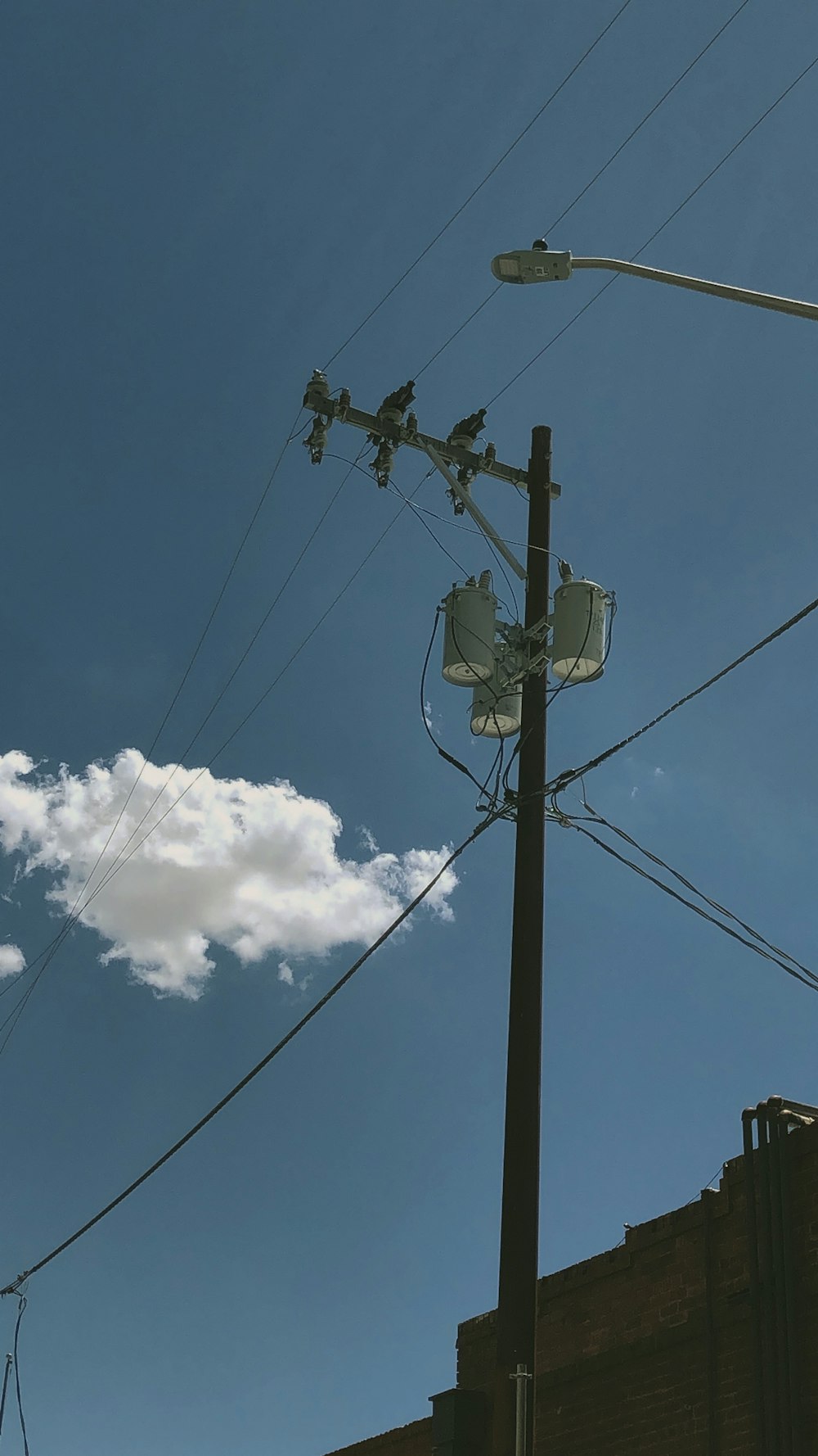 white clouds over black electric post