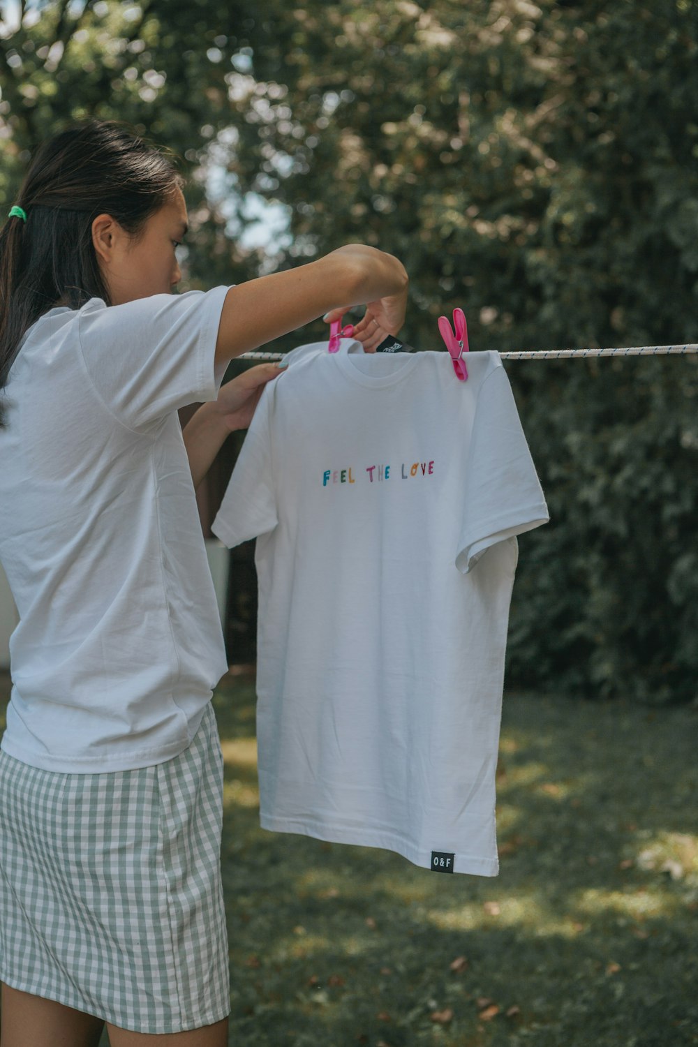 woman in white t-shirt holding white plastic clothes hanger